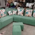 Green corner sofa with floral pillows